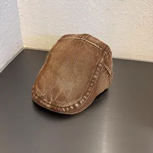 Dettaglio del berretto piatto in denim marrone lavato con trama vintage e cuciture