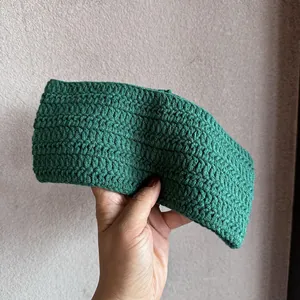 Nahaufnahme von dunkelgrünem handgestricktem Stirnband mit dicker Textur und Handarbeit
