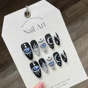 Matte press-on nails with mystical evil eye and crescent moon designs in black and white