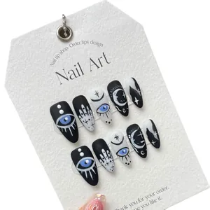 Handmade press-on nails with mystical black and white graffiti eyes and gothic patterns