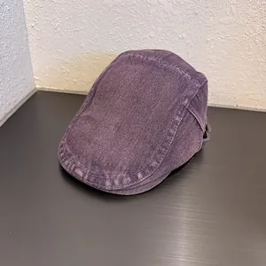Dettaglio del berretto piatto in denim lavato viola con fibbia in metallo regolabile