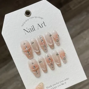 Handmade cat eye press-on nails with pearls, crystals, and gradient pink long coffin shape