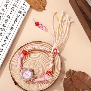 Dettaglio dell'orologio intrecciato bohémien con perline rosa e accenti di strass sul quadrante