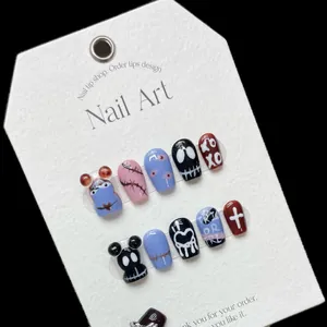 Hand-painted Halloween cartoon press-on nails with blue and pink patterns on white card