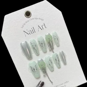 Handmade light green press-on nails featuring silver butterfly motifs and metal chains