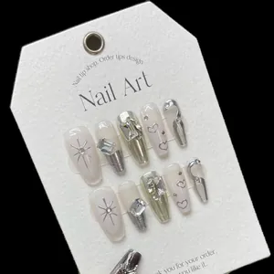 Faux ongles faits main blanc aurore avec cœurs argentés et strass brillants