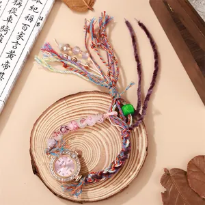 Montre bohème à bracelet tissé avec lunette en strass et pompon perlé sur bois