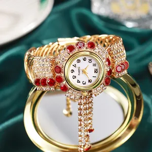 Luxuriöse Damen-Armbanduhr in Gold mit Kristallen und Quasten auf grünem Seidengrund