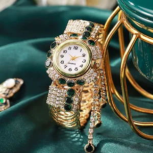 Luxuriöse goldene Quarzuhr mit smaragdgrünen Steinen und glitzernden Quasten-Details