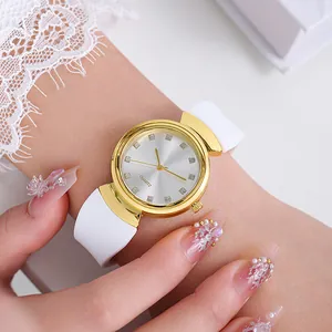Close-up of stylish white quartz watch with gold case and rhinestone markers on wrist