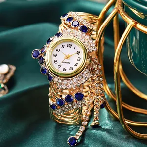 Luxurious gold vintage women watch with tassel and crystals on dark green satin