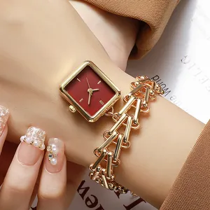 Detail of square gold watch with vintage red dial and double-row bamboo chain strap