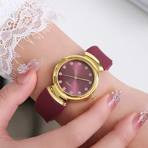 Close-up of elegant gold watch with purple dial and rhinestone markers on female wrist
