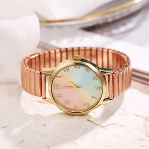 Close-up of rose gold watch featuring a rainbow gradient dial and elastic metal band