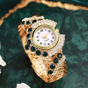 Close-up of luxury gold quartz watch with emerald crystals and rhinestone bezel details