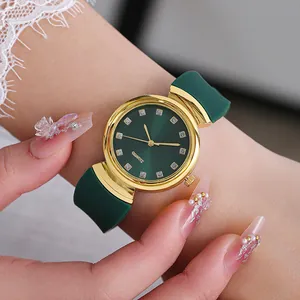 Detail of a ladies' green quartz watch with gold case and crystal markers on wrist
