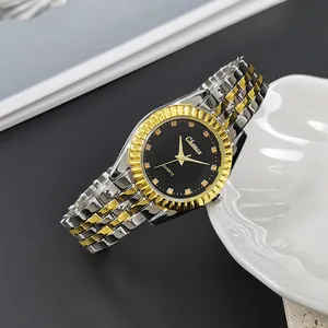 Detailed close-up of quartz watch with black sunburst dial and gold fluted bezel design