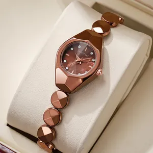 Gros plan sur montre dorée rose avec cristal et cadran brun à coupe géométrique