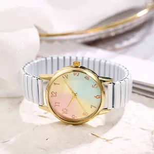 Macro detail of gold watch case featuring rainbow gradient dial and white stretch band