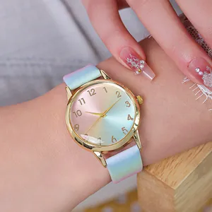 Gros plan d'une montre quartz pour femme avec boîtier doré et cadran dégradé rose