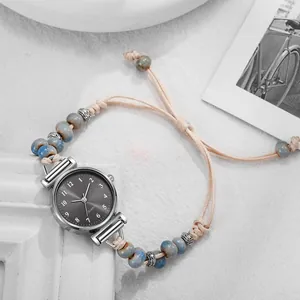 Detalle de reloj pulsera con cuentas de cerámica azul y correa trenzada ajustable