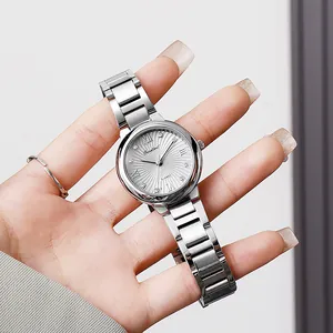 Detailed close-up of a luxury silver steel watch with diamond markers and sunray dial