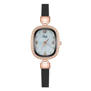Detail of rose gold oval quartz watch with crystal bezel and black leather strap