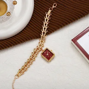 Detail of vintage square red dial watch with golden geometric hollow chain strap