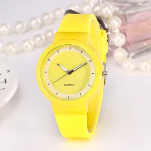 Close-up of vibrant yellow quartz watch with silicone strap and elegant accessories
