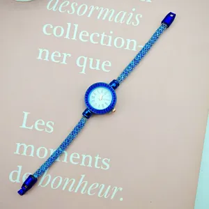 Detailed macro view of the blue crystal mesh strap and the round Roman numeral dial