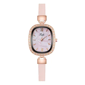 Macro detail of rose gold oval watch case with sparkling diamonds and pink leather strap