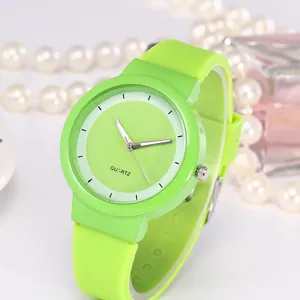 Detailed view of the neon green quartz watch dial with silver hands on a fashion background