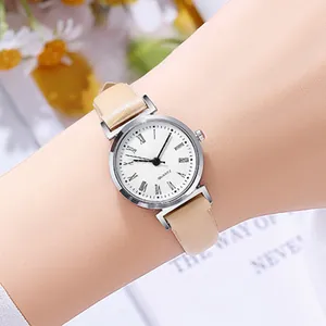 Close-up of minimalist silver quartz watch with Roman numerals and beige leather strap