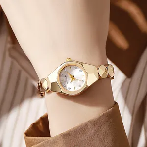 Détail macro d'une montre à quartz dorée avec un bracelet métallique à facettes géométriques