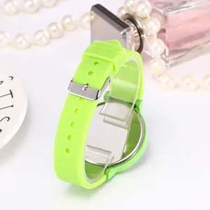 Detail of neon green silicone watch strap with silver buckle and metallic back cover