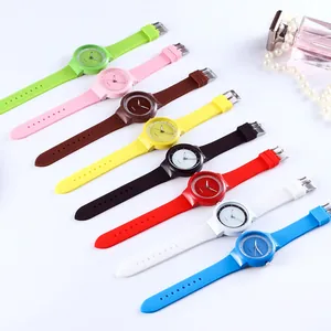 Flat lay of colorful silicone quartz watches with stylish perfume and pearl accessories