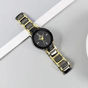 Close-up of dual-tone black and gold quartz watch with diamond-set hour markers