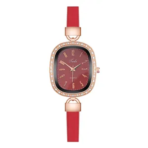Detailed close-up of oval rose gold watch case with crystal inlay and red leather strap