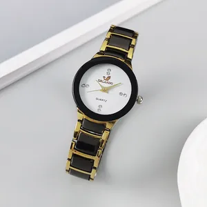 Close-up of elegant women watch with rhinestone markers and black gold link bracelet