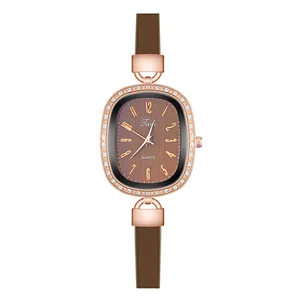 Detailed view of an oval rose gold watch with crystal bezel and brown leather strap