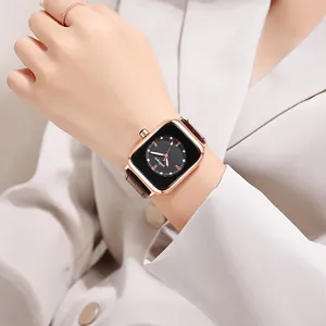Detail showing woman wearing square rose gold quartz watch with brown leather strap