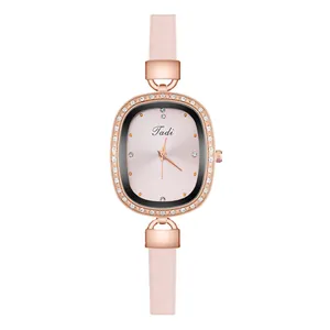 Close-up of elegant rose gold oval watch with rhinestone bezel and pink leather strap