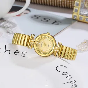 Gros plan d'une montre à quartz dorée avec marqueurs en strass sur une assiette blanche