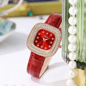 Detail of square rose gold watch with rhinestone bezel and burgundy leather strap