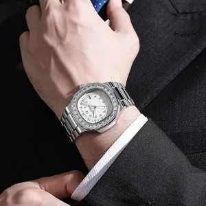 Detail of luxury men's steel watch with diamond bezel and white dial worn with a suit