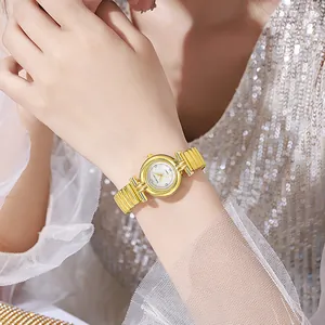 Gros plan d'une montre à quartz dorée avec bracelet à maillons sur une robe à paillettes