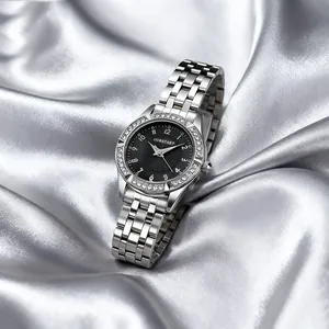 Detail showing crystal-encrusted bezel and black dial of a polished steel watch