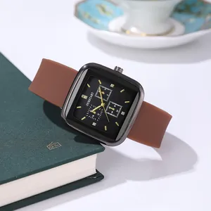 Close-up of square black quartz watch dial with brown silicone strap on a vintage book