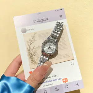 Detail of silver ladies watch with crystal bezel and Roman numerals in creative frame