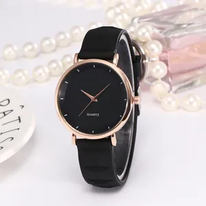 Gros plan d'une montre à quartz avec boîtier or rose et bracelet en silicone noir